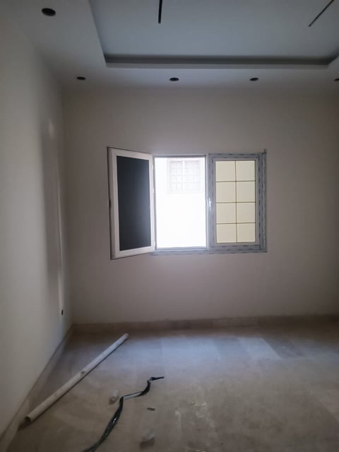 Empty room under construction with three windows