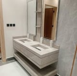 Modern bathroom vanity with dual rectangular sinks, concrete and white countertop, large mirror, and minimal wall-mounted fixtures