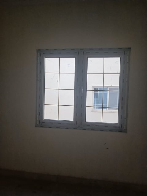 Gray-framed windows with white panes on beige wall