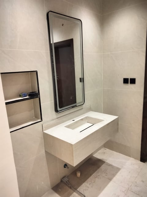Modern bathroom vanity with white sink counter, black-framed mirror