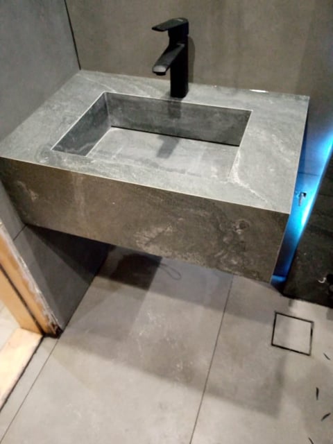 Modern concrete vanity sink with black faucet in minimalist bathroom